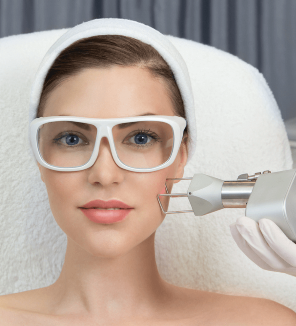 A woman in a medical spa with white glasses on getting skin laser treatment to reduce wrinkles as a part of anti-aging.
